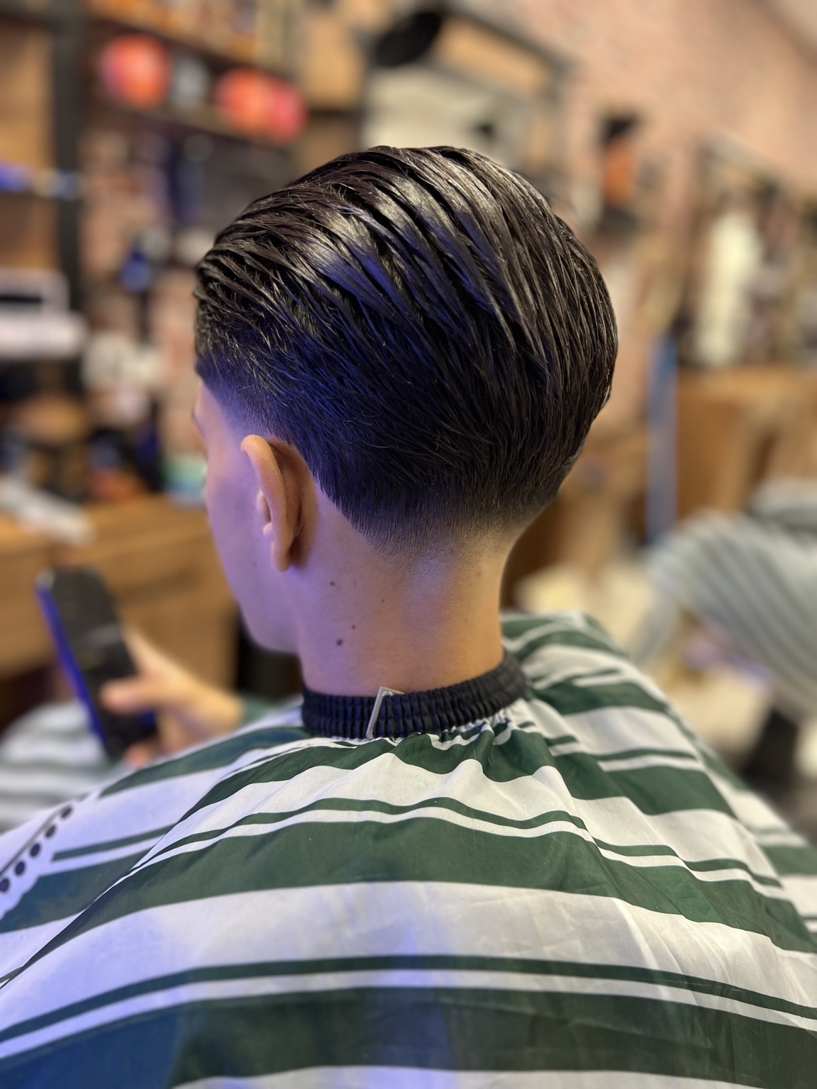 Coupe coiffée en arrière et dégradé réalisés chez CS Barber