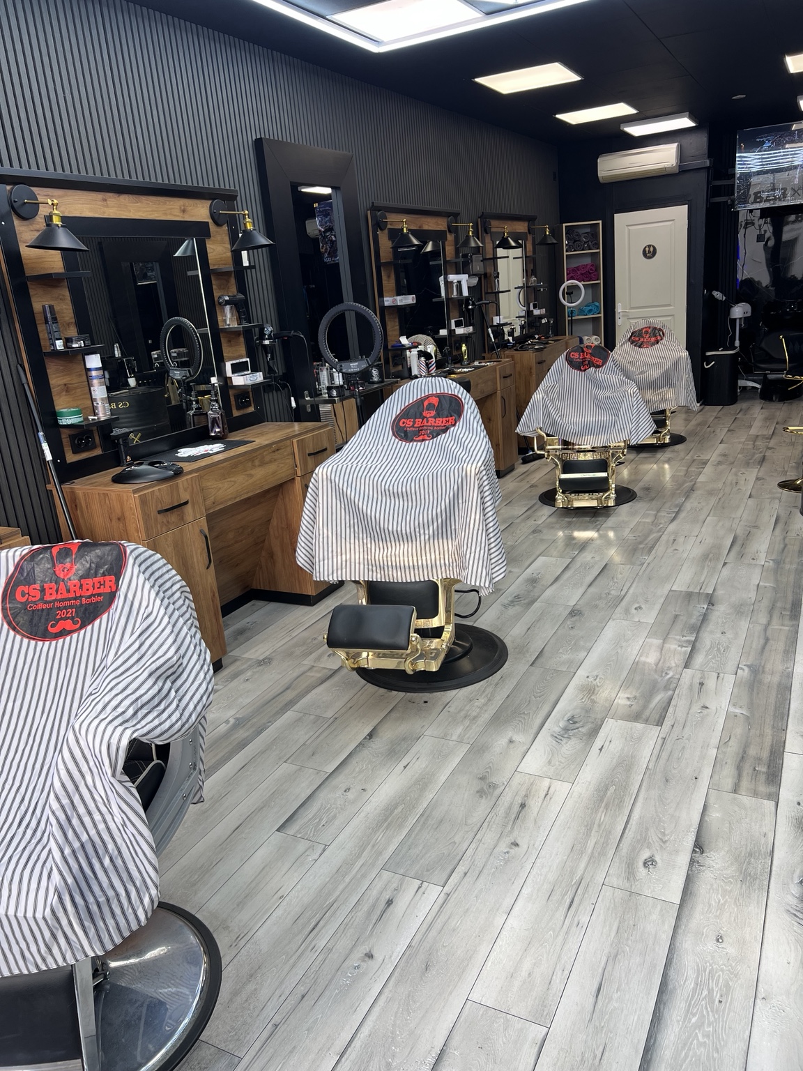 Le salon CS Barber actuel, plafond noir et fauteuils de barbier